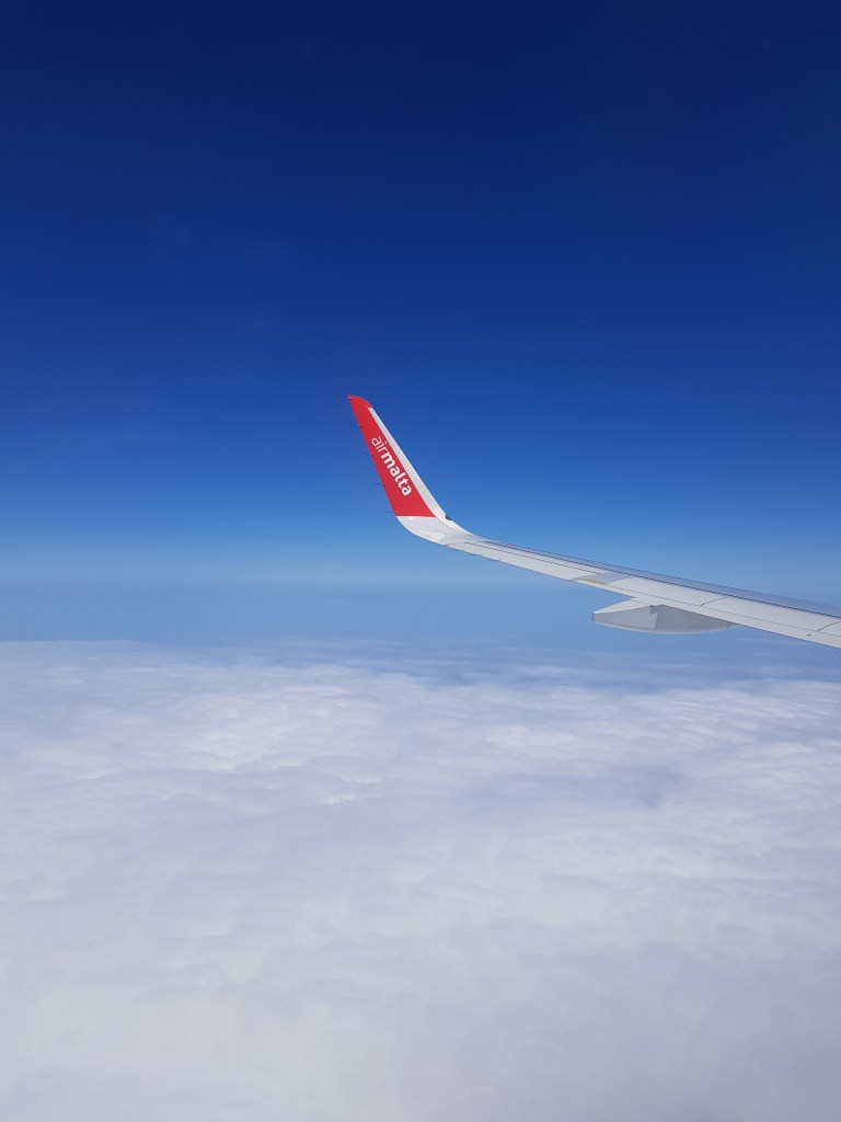 photo of airmalta airplane wind in the sky above the clouds