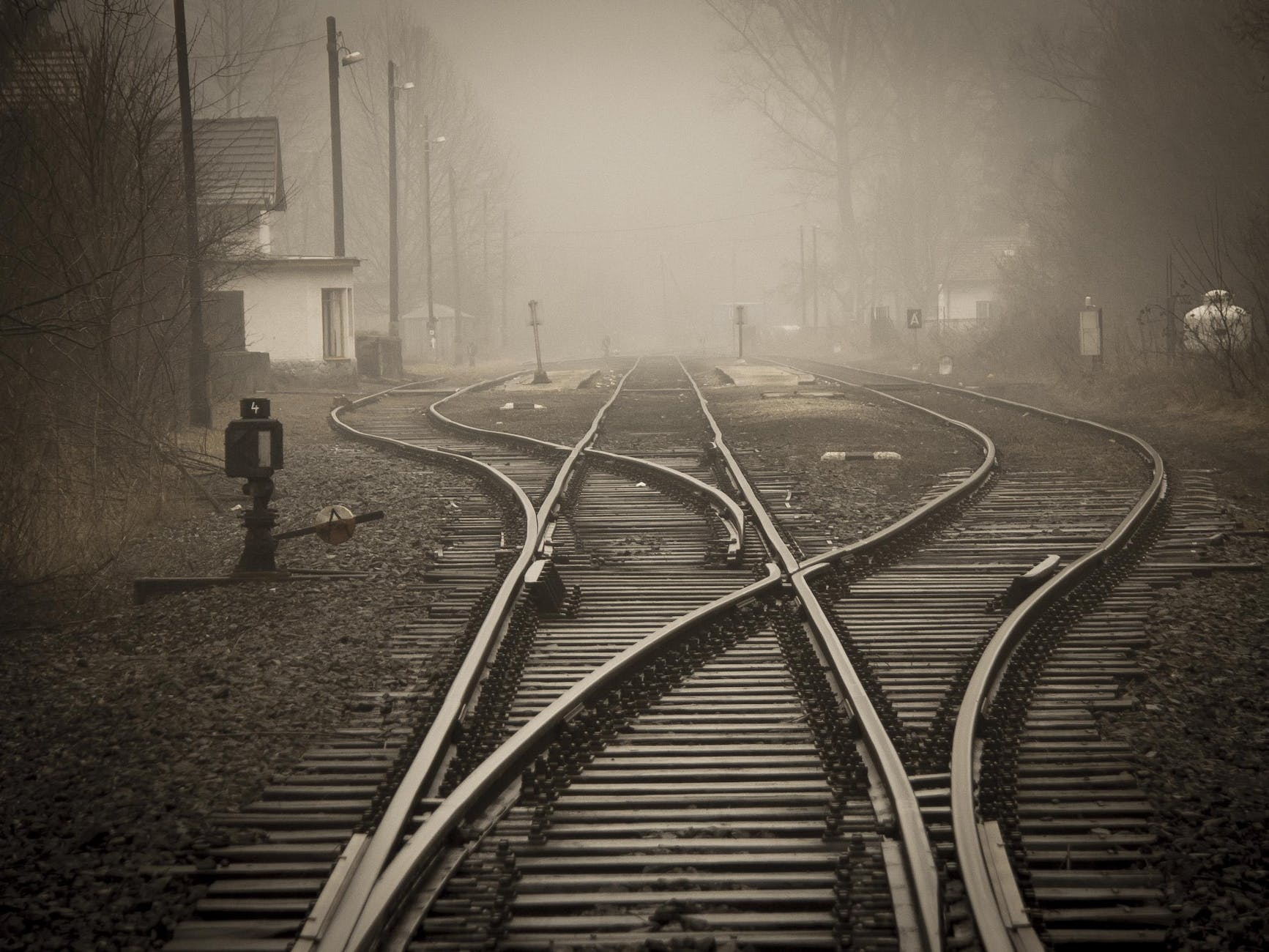 photo of diverging railroad tracks on a foggy day