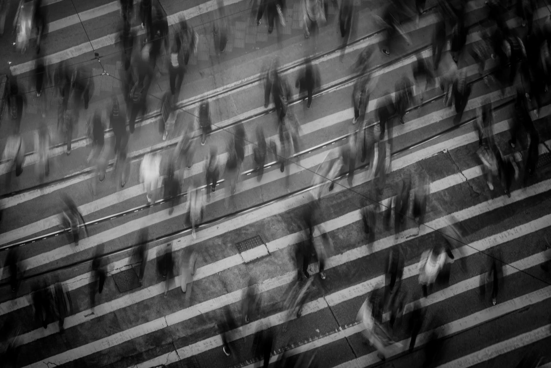 photo of blurred people crossing a zebra crossing